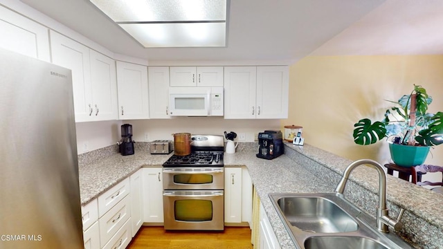 kitchen featuring white cabinetry, sink, light hardwood / wood-style flooring, and appliances with stainless steel finishes