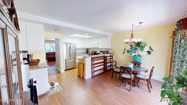 dining room with a notable chandelier and light hardwood / wood-style flooring