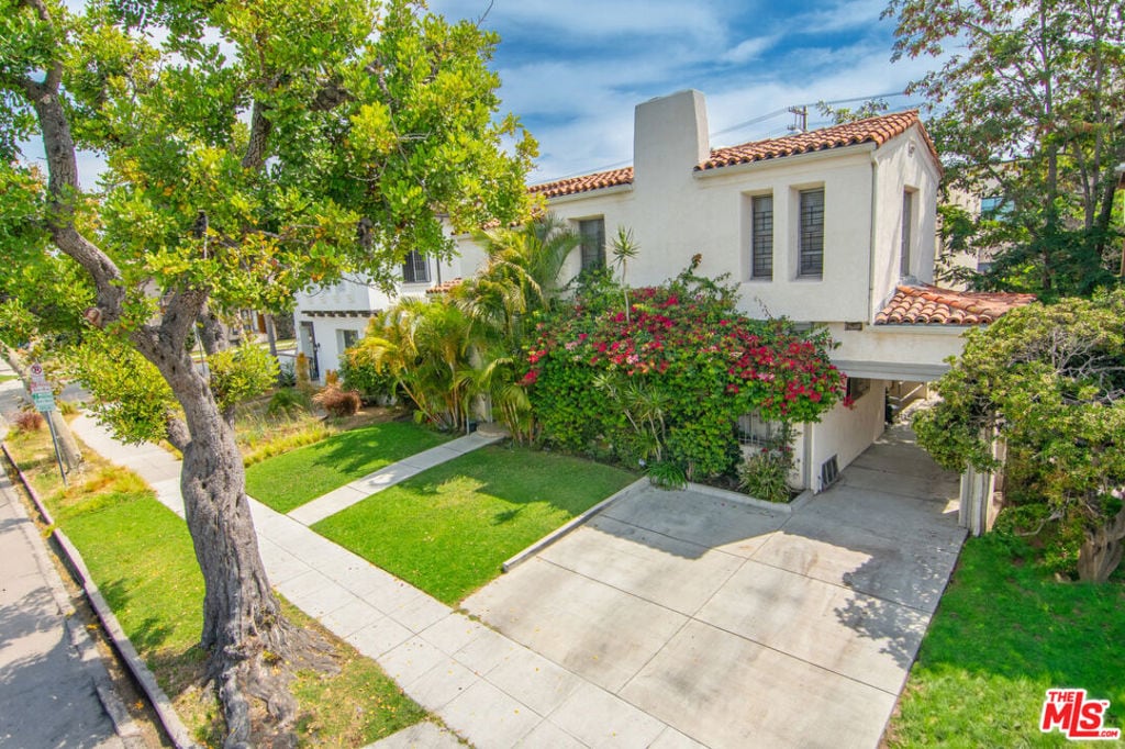 mediterranean / spanish-style home with a front lawn and a carport