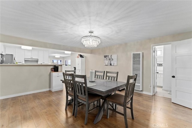 dining area with an inviting chandelier and light hardwood / wood-style floors