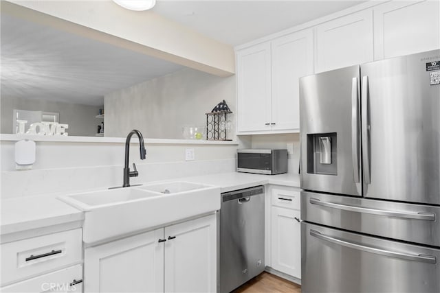 kitchen with white cabinetry, sink, light hardwood / wood-style flooring, and stainless steel appliances