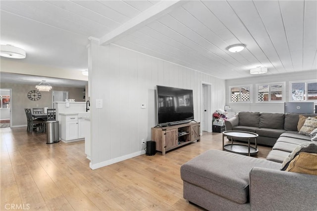 living room with wood ceiling, light hardwood / wood-style flooring, a chandelier, and beamed ceiling