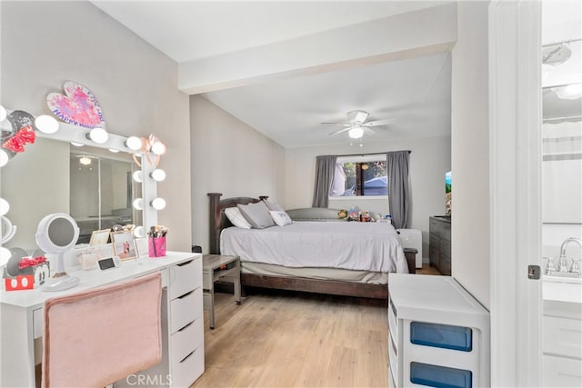 bedroom with beamed ceiling, light wood-type flooring, sink, and ceiling fan