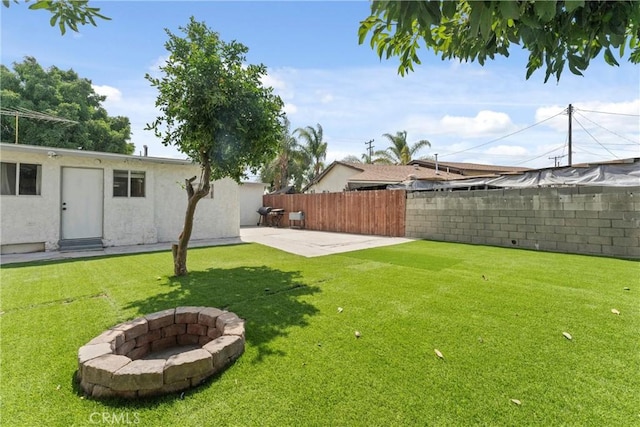 view of yard featuring an outdoor fire pit and a patio