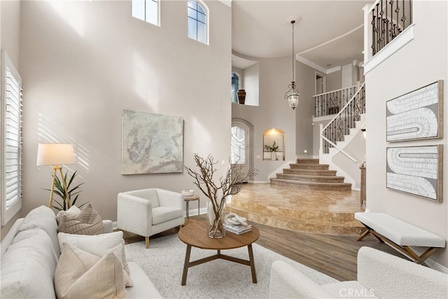 living room featuring a healthy amount of sunlight, a high ceiling, and hardwood / wood-style flooring