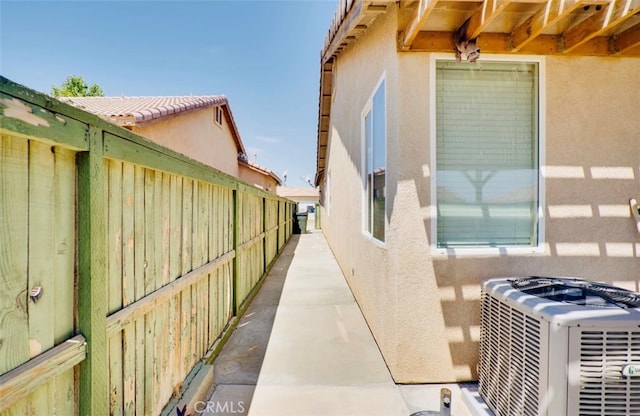 view of side of property with a patio area and central AC