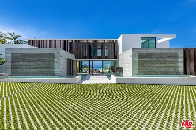 rear view of house featuring a yard