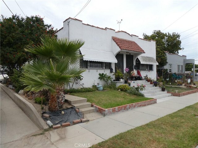 mediterranean / spanish house featuring a front yard