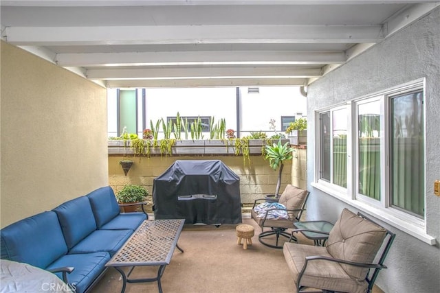 sunroom with a healthy amount of sunlight and beam ceiling