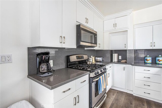 kitchen featuring white cabinets, appliances with stainless steel finishes, dark hardwood / wood-style floors, and tasteful backsplash