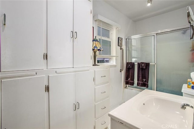 bathroom with vanity and a shower with door