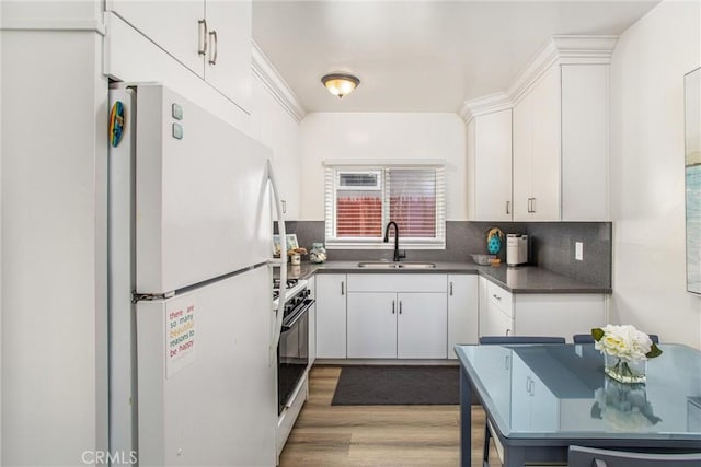 kitchen with white cabinetry, sink, white appliances, and tasteful backsplash