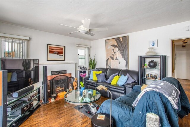 living room with ceiling fan, hardwood / wood-style floors, and a fireplace