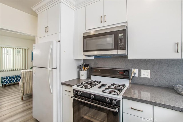 kitchen with range with gas cooktop, white fridge, decorative backsplash, light wood-type flooring, and white cabinets