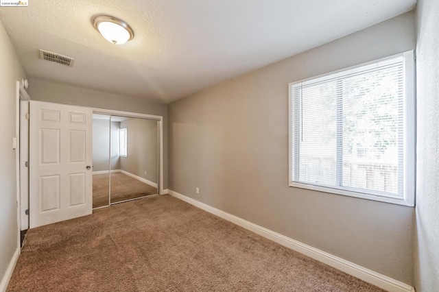 unfurnished bedroom with carpet flooring and a closet