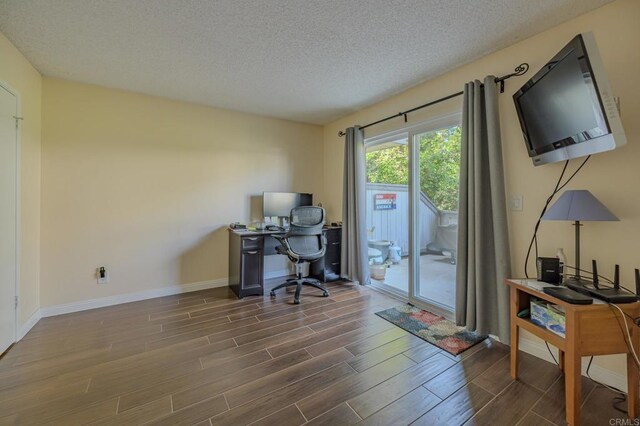 office area with dark hardwood / wood-style floors and a textured ceiling