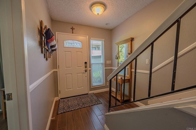 entrance foyer with a textured ceiling and dark hardwood / wood-style flooring