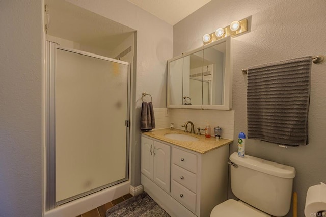 bathroom with tile patterned flooring, vanity, walk in shower, and toilet