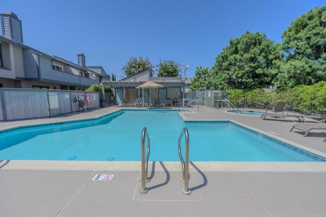 view of swimming pool featuring a hot tub, a patio, and a pergola