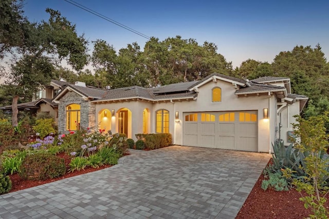 mediterranean / spanish home with a garage and solar panels