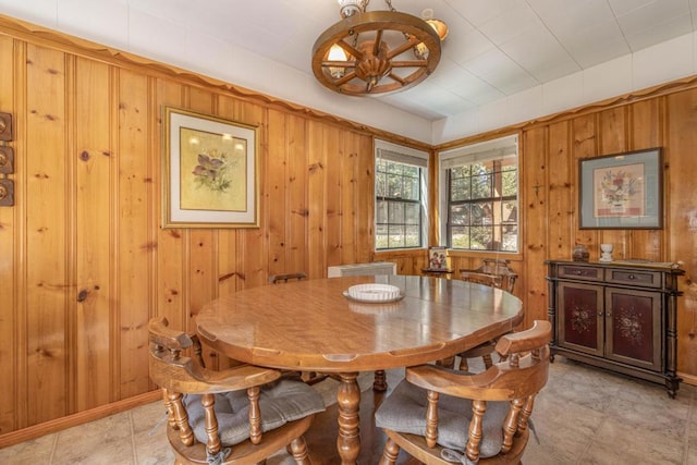 dining space featuring wood walls