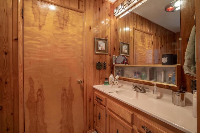 bathroom featuring vanity and wooden walls