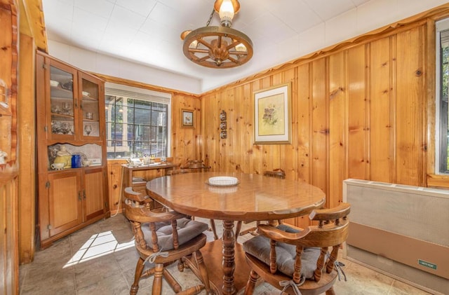 dining space featuring radiator and wooden walls