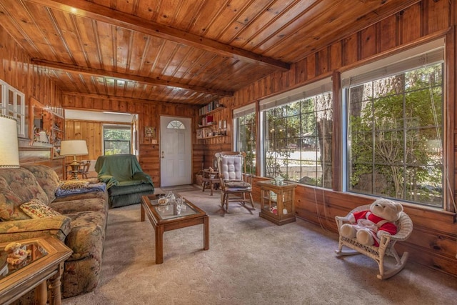 carpeted living room featuring beam ceiling, wooden walls, and wood ceiling