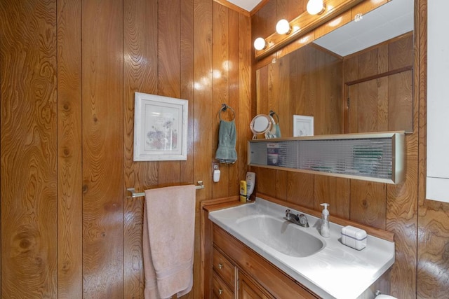 bathroom with vanity and wood walls