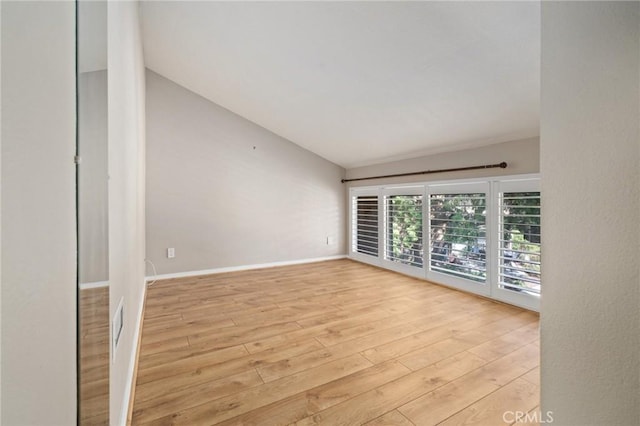 empty room with lofted ceiling and light wood-type flooring