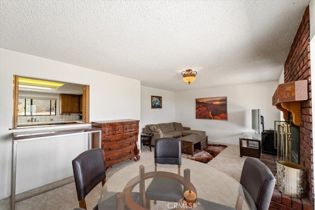 carpeted living room featuring a fireplace and a textured ceiling