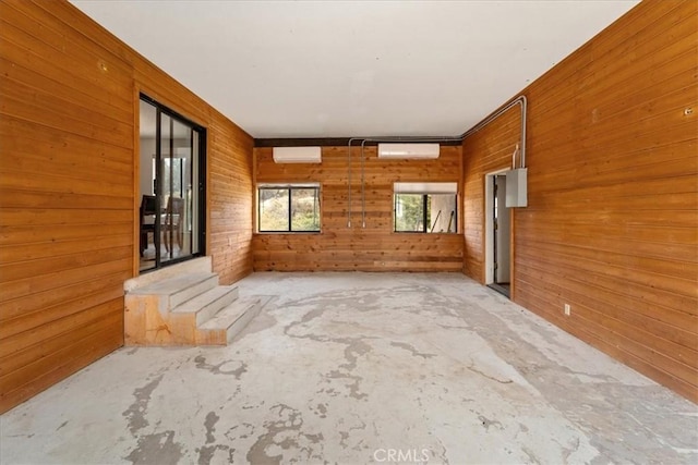 unfurnished room with wooden walls and a wall mounted AC