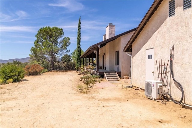 view of home's exterior featuring a mountain view and ac unit