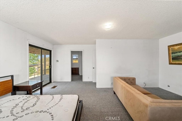 bedroom with carpet flooring, a textured ceiling, and access to outside