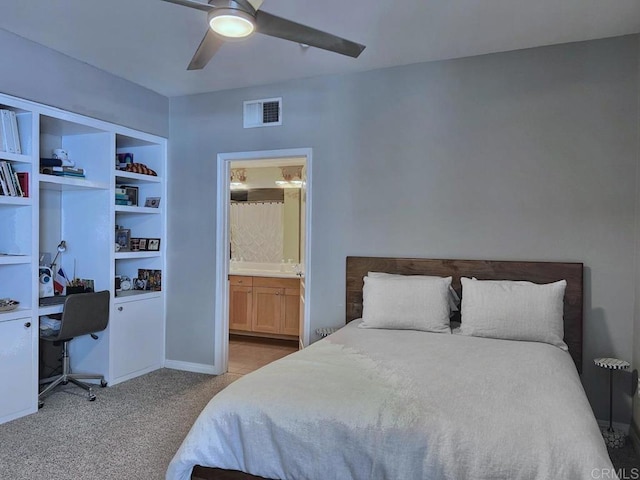 bedroom featuring a ceiling fan, visible vents, connected bathroom, and light colored carpet