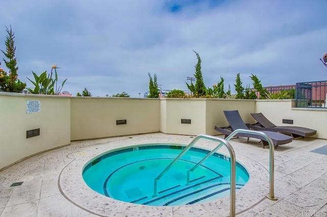 view of swimming pool with a hot tub