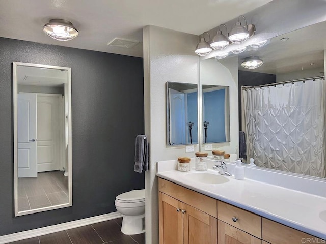bathroom featuring vanity, a textured wall, baseboards, toilet, and a shower with shower curtain