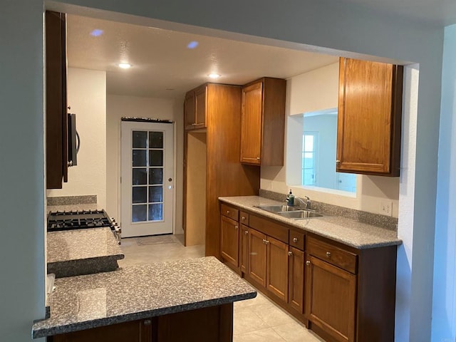 kitchen with light tile patterned floors, stainless steel stove, and sink