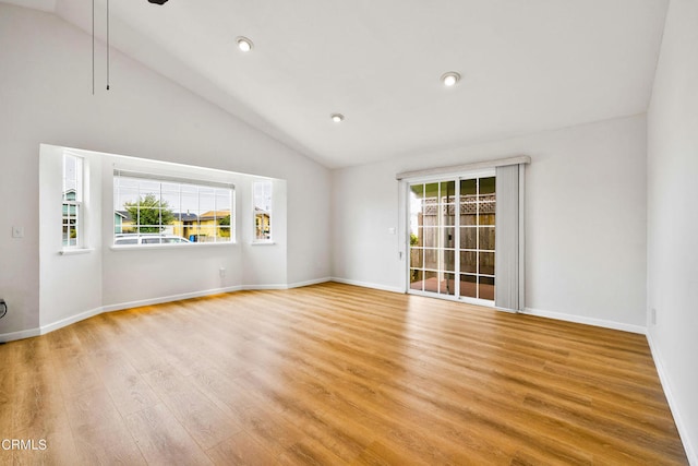 empty room featuring beamed ceiling, light hardwood / wood-style floors, high vaulted ceiling, and a wealth of natural light