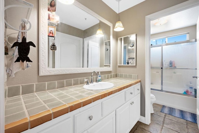 full bathroom with toilet, combined bath / shower with glass door, and vanity