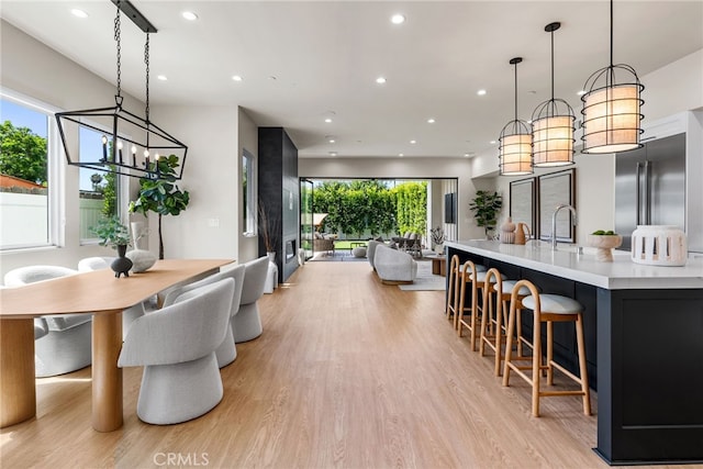 dining room featuring light hardwood / wood-style flooring, a notable chandelier, and sink