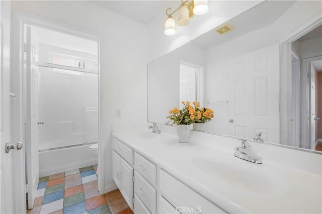 bathroom featuring double vanity, visible vents, toilet, and a sink