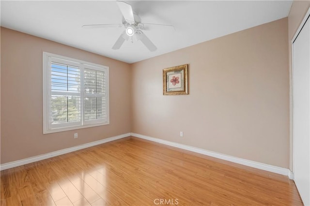 empty room featuring light wood-style floors, ceiling fan, and baseboards