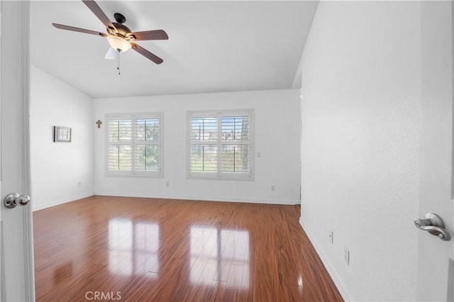 unfurnished room with lofted ceiling, baseboards, a ceiling fan, and wood finished floors