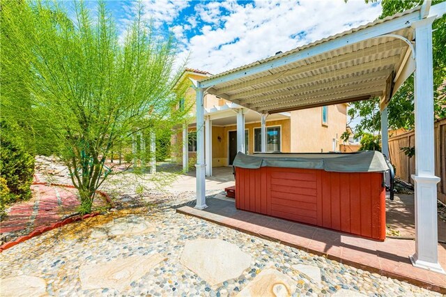 view of patio / terrace with a pergola and a hot tub