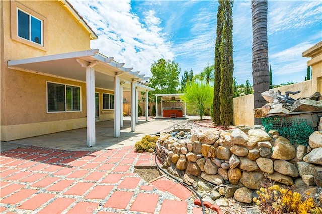 view of patio / terrace with a hot tub and a pergola