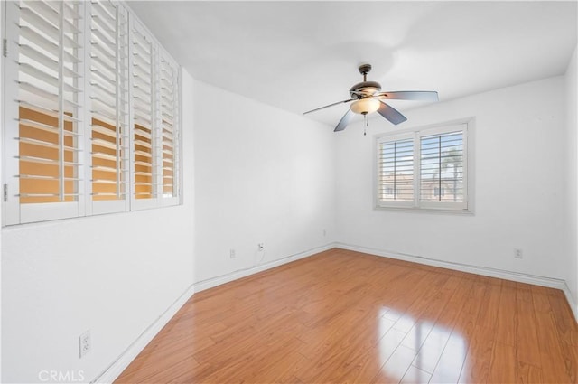 unfurnished room featuring ceiling fan, baseboards, and wood finished floors