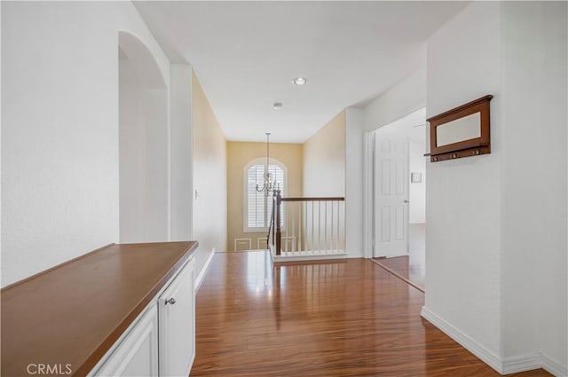 corridor with an inviting chandelier and light wood-type flooring