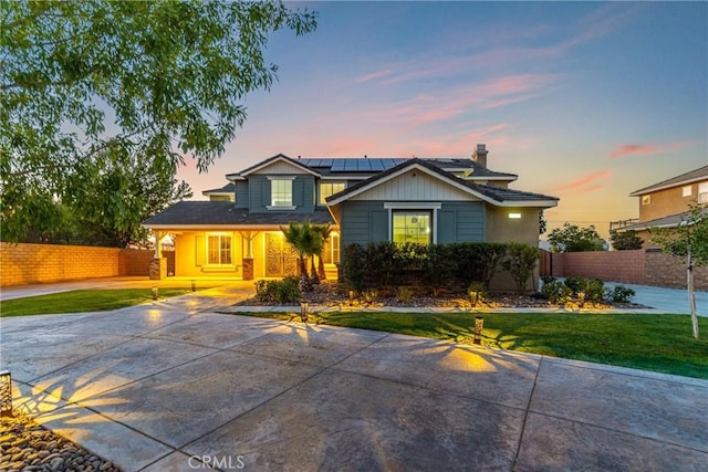 view of front of property with a yard and solar panels