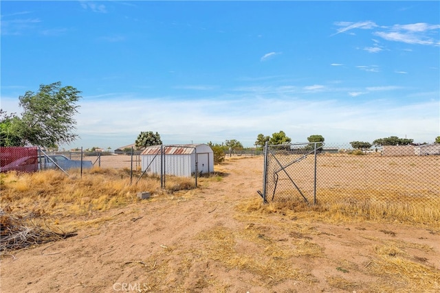 view of yard with a shed and a rural view